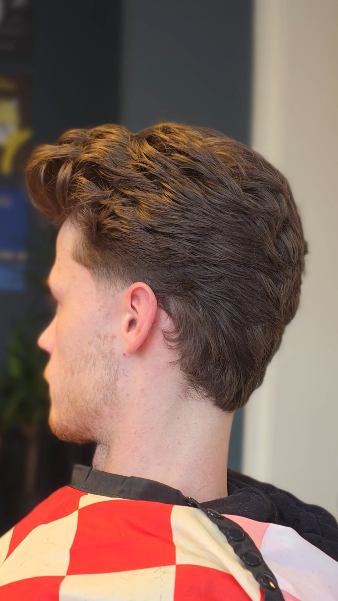 Getextureerde knipbeurt met volume bovenop, van opzij